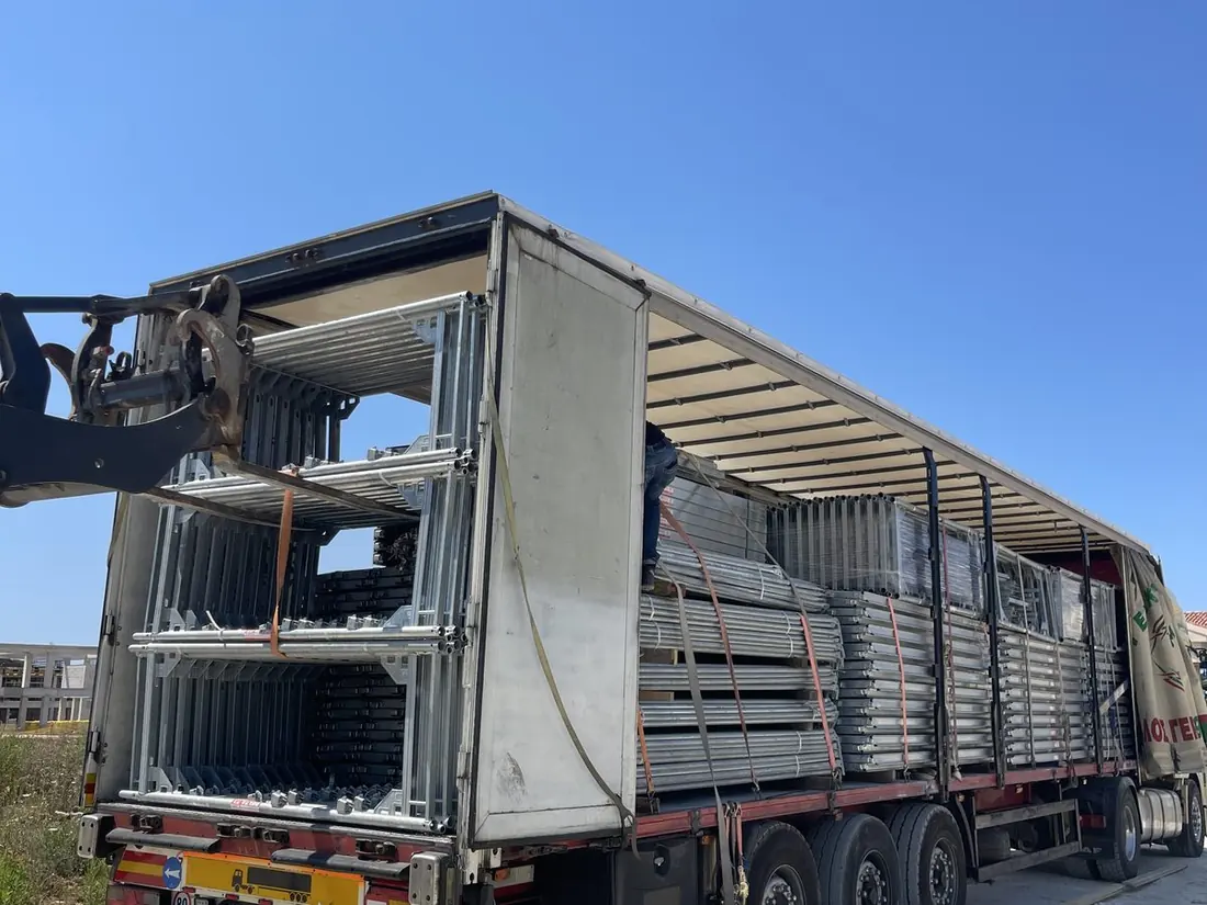 A DNM Construction trailer loaded with stacked scaffolding frames ready for delivery
