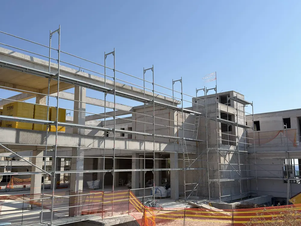Scaffolding surrounding a multi-storey concrete frame under construction