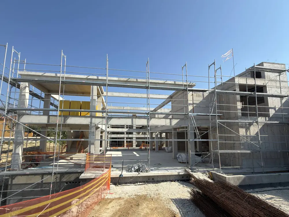 Scaffolding levelled on a sloping excavated site next to a rock face